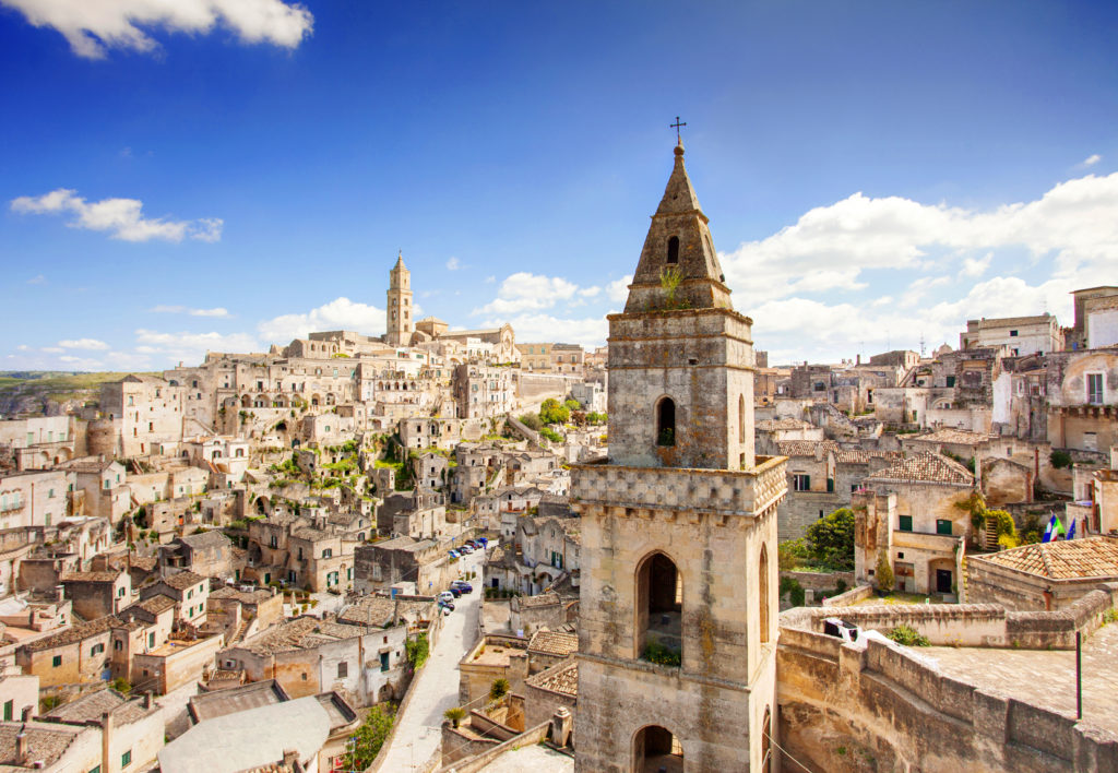 An impressive view of Matera, looking over the levels of the city from a bird's eye view, surrounded by a lovely crispy blue sky