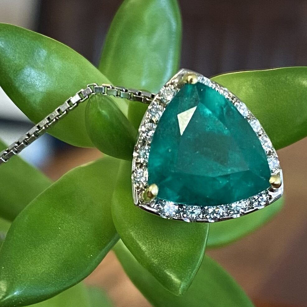 A trillion cut emerald and diamond neck