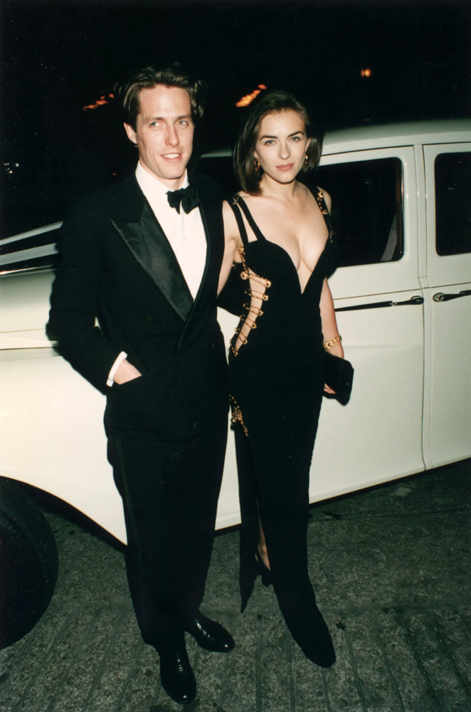 Elizabeth Hurley and Hugh Grant attending the film premiere, with focus on Hurley’s stunning Versace gown 
