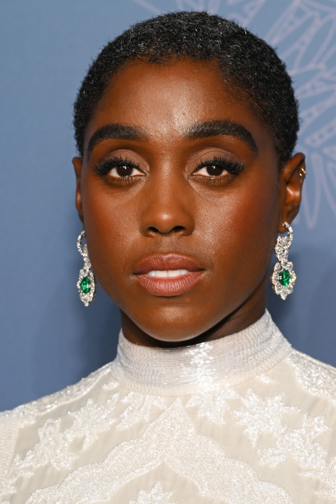 Lashana Lynch, wearing intricate Emerald and Diamond earrings