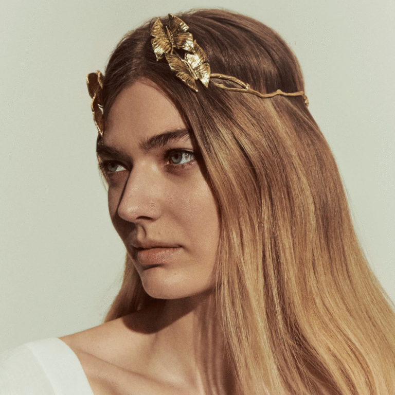 Person with long hair wears a gold leaf headband.