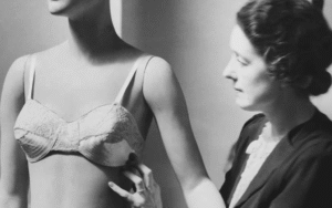 Woman adjusts a bra on a mannequin.