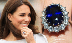Person smiling, wearing a ring with a large blue stone surrounded by diamonds. Ring close-up.