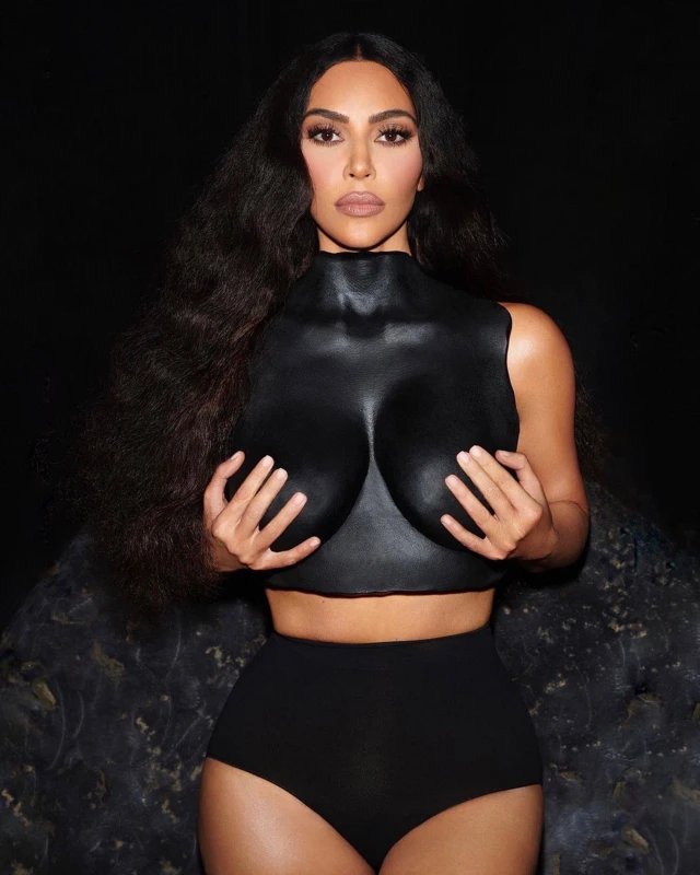 Person in black top and shorts holds hands to chest.